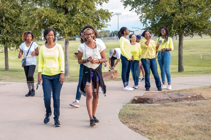 A group of people walking on the sidewalk.